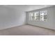 Spacious bedroom with plush carpeting and three bright windows overlooking an outdoor area at 1415 Great Western Dr, Longmont, CO 80501