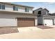 Two-story home displays a two-car garage and gray horizontal siding at 1415 Great Western Dr, Longmont, CO 80501