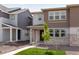 Attractive two-story house with a blend of stone and siding, highlighted by a green lawn and budding tree at 1415 Great Western Dr, Longmont, CO 80501
