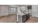 View of an open-concept kitchen with island seating, stairs, and stainless steel appliances at 1415 Great Western Dr, Longmont, CO 80501