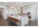 Bright white kitchen with stainless steel appliances, large island, and pendant lighting at 36 Stableford Pl, Castle Pines, CO 80108