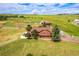 Stunning aerial view of a home on sprawling acreage, featuring well-maintained lawns and outbuildings at 35675 Cheyenne Trl, Elizabeth, CO 80107