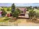 Scenic backyard featuring a wooden deck, small shed, and mature trees, all enclosed by a classic white fence at 35675 Cheyenne Trl, Elizabeth, CO 80107