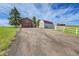 Exterior of home and barn including a large drive and grass area at 35675 Cheyenne Trl, Elizabeth, CO 80107