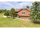 Charming home with lush lawn and mature trees offering a tranquil curb appeal and inviting entrance at 35675 Cheyenne Trl, Elizabeth, CO 80107