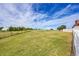 Expansive grassy land with a white fence, offering a serene and picturesque view under a bright blue sky at 35675 Cheyenne Trl, Elizabeth, CO 80107