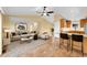 Open concept living room and kitchen space with hardwood floors, ceiling fan, and bar top seating at 35675 Cheyenne Trl, Elizabeth, CO 80107
