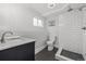 Modern bathroom featuring a shower with white subway tile, black hex tile flooring, and a marble vanity at 217 Douglas Fir Ave, Castle Rock, CO 80104