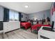 Spacious shared bedroom with two red twin beds, white dresser, city skyline wall decor, and modern accents at 217 Douglas Fir Ave, Castle Rock, CO 80104