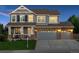 Charming two-story home with a stone facade, manicured lawn, and a three-car garage at 7083 Winthrop Cir, Castle Rock, CO 80104
