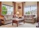 Cozy living room featuring neutral tones, plush sofas, and natural light from large windows at 7083 Winthrop Cir, Castle Rock, CO 80104