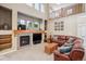 Spacious living room with a fireplace, large windows, and comfortable leather seating at 7083 Winthrop Cir, Castle Rock, CO 80104