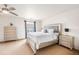 This bedroom boasts a ceiling fan and light, complemented by matching dressers and a bright window at 21354 E 51St Ave, Denver, CO 80249