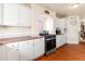 Kitchen with stainless steel gas range and lots of cabinet space plus arch to living room at 21354 E 51St Ave, Denver, CO 80249