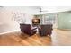 Inviting living room area featuring hardwood flooring, tree wall art and two comfortable leather chairs at 21354 E 51St Ave, Denver, CO 80249