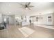 Bright open-concept living room with a ceiling fan, hardwood floors, and modern kitchen at 12639 Lake Terrace St, Firestone, CO 80504