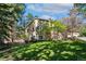 Lush backyard of the house with tall trees, a well-kept lawn and a glimpse of an outdoor living space at 20190 Deer Shadow Way, Monument, CO 80132