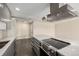 Bright kitchen features stainless steel range hood and dark hardwood floors at 955 Eudora St # 207E, Denver, CO 80220