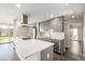 Close-up of a kitchen island featuring stainless steel appliances, grey cabinetry, hardwood floors, and a quartz countertop at 955 Eudora St # 207E, Denver, CO 80220