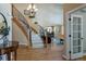 Elegant foyer with hardwood floors, a curved staircase with iron railings, and views into the dining and living areas at 10859 Irving Ct, Westminster, CO 80031