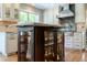 Close-up of the kitchen island showcasing glass-front cabinets, granite countertop, and elegant display at 10859 Irving Ct, Westminster, CO 80031