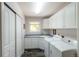 Functional laundry room equipped with modern washer and dryer, storage cabinets, and folding counter at 10859 Irving Ct, Westminster, CO 80031