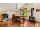 Charming dining area with wood-burning stove, rustic table, and a large window overlooking the surrounding forest at 422 Fairview Blvd, Breckenridge, CO 80424