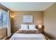 Comfortable bedroom featuring a queen size bed, side tables, and an abstract floral print at 5886 Urban St, Arvada, CO 80004