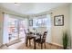 Bright dining area features sliding glass doors to a deck, and a round wood table on top of a jute rug at 5886 Urban St, Arvada, CO 80004