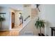 Welcoming foyer with hardwood floors, staircase, and views into the kitchen, creating an open and inviting space at 5886 Urban St, Arvada, CO 80004