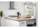 Bright kitchen featuring an island with a butcher block countertop, stainless steel appliances, and white subway tile backsplash at 5886 Urban St, Arvada, CO 80004
