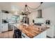 A modern kitchen with stainless steel appliances, white cabinets, and a butcher block island at 5886 Urban St, Arvada, CO 80004