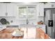 Kitchen with stainless steel appliances, white cabinets, tile backsplash, and a butcher block countertop island at 5886 Urban St, Arvada, CO 80004