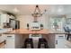 Bright kitchen with a large butcher block island, white cabinets and stainless steel appliances at 5886 Urban St, Arvada, CO 80004