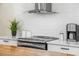 Stylish kitchen showcasing a stainless steel range, white cabinetry, quartz countertops, and decorative elements at 5886 Urban St, Arvada, CO 80004