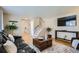 Cozy living room featuring hardwood floors, leather seating, wood chest, and staircase at 5886 Urban St, Arvada, CO 80004