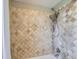Tiled shower with stone look tiles and shower head at 5886 Urban St, Arvada, CO 80004
