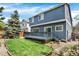 Spacious backyard featuring a well-maintained lawn, deck, and mature trees for privacy at 9885 Thornbury Way, Highlands Ranch, CO 80129