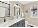 Modern bathroom features dual sinks, sleek black fixtures, and ample natural light from the window at 9885 Thornbury Way, Highlands Ranch, CO 80129