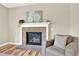 Living room featuring a brick fireplace, chair, and a mantle decorated with greenery at 9885 Thornbury Way, Highlands Ranch, CO 80129