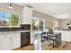 Bright kitchen with white cabinets, stainless steel dishwasher and breakfast nook area at 9885 Thornbury Way, Highlands Ranch, CO 80129