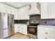 Kitchen featuring white cabinets, stainless steel appliances and hardwood floors at 9885 Thornbury Way, Highlands Ranch, CO 80129