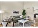 Cozy living area with plush seating, a white coffee table, and views to the kitchen for easy living at 9885 Thornbury Way, Highlands Ranch, CO 80129
