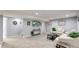 Open basement area featuring a large tv, neutral carpet, and comfortable seating arrangements at 8438 Ames St, Arvada, CO 80003