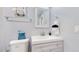 Clean bathroom with gray vanity, framed mirror, toilet, and a towel rack at 8438 Ames St, Arvada, CO 80003