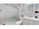 Bathroom featuring tiled shower, glass doors, and sleek vanity with sink and storage at 8438 Ames St, Arvada, CO 80003