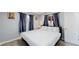 Bedroom featuring neutral paint, carpet, and a bed with white linens and patterned curtains at 8438 Ames St, Arvada, CO 80003