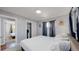 Bedroom with neutral carpet, white bed linens, and patterned curtains provides a tranquil space at 8438 Ames St, Arvada, CO 80003