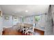 Spacious dining area features hardwood floors, neutral paint, and a large dining table at 8438 Ames St, Arvada, CO 80003