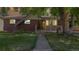 Charming brick home with well-manicured lawn, framed by a mature tree at 8438 Ames St, Arvada, CO 80003
